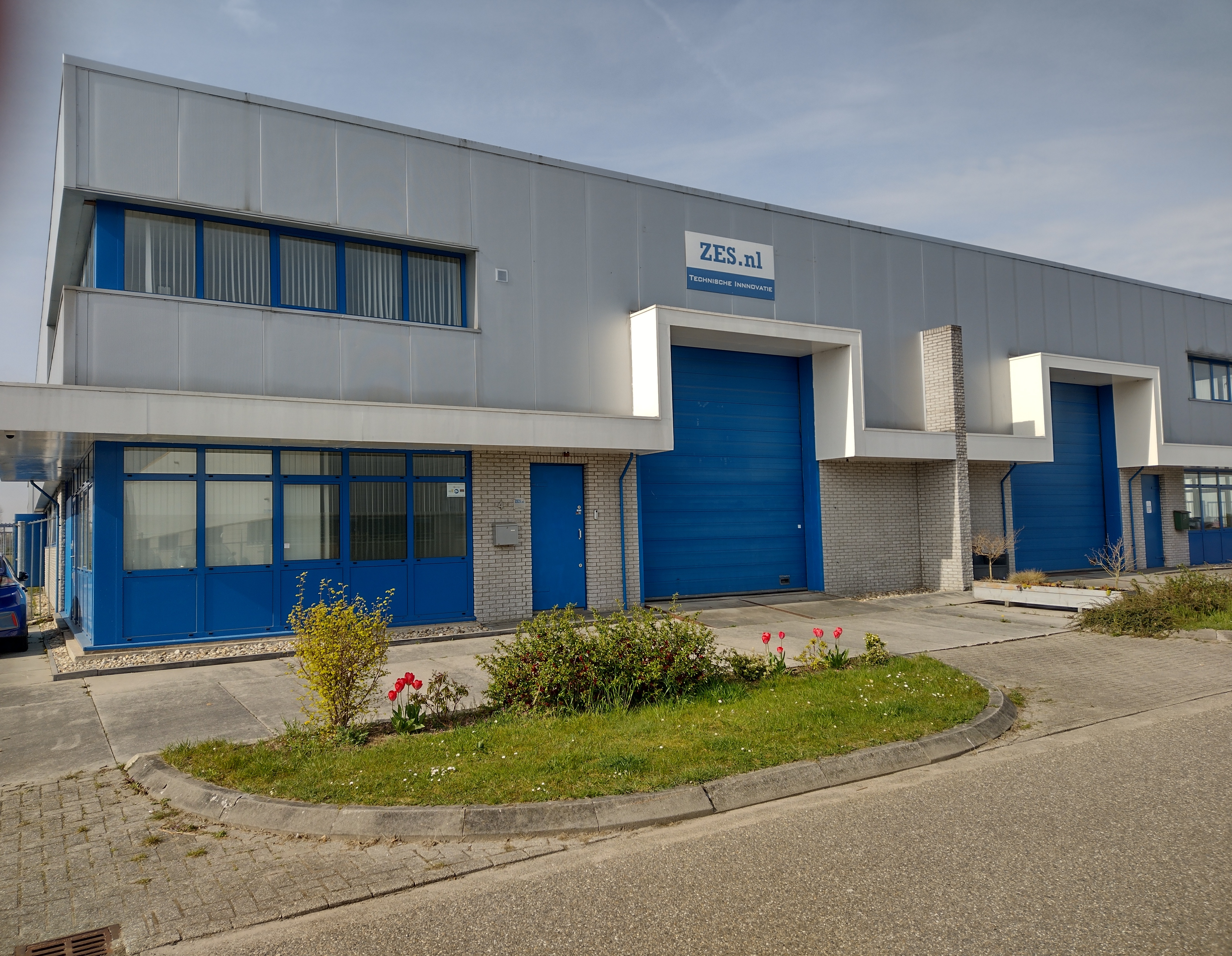 Het bedrijfspand van Z.E.S. aan de Hydrograaf in Duiven, met blauwe deuren en het ZES.nl-bord aan de gevel